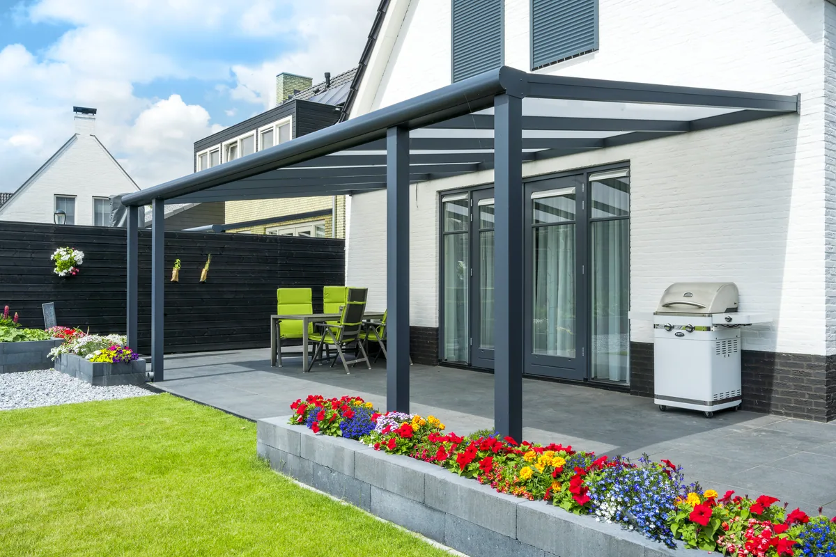 Anthracite Bosco glass veranda over a patio with flower borders